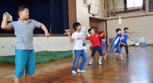 紙飛行機を飛ばし、滞空時間を競う児童