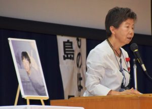 市立郡山中学校で行われた「命の大切さを学ぶ教室」で講演する児島早苗さんと長男の健仁さんの遺影