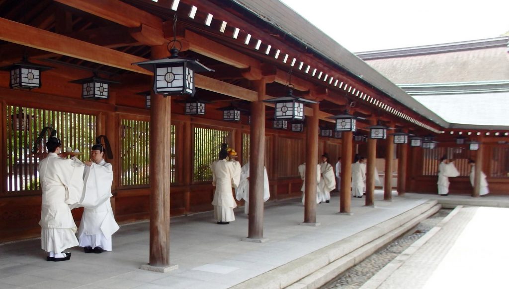 回廊に並び、神饌を受け渡しする神職ら