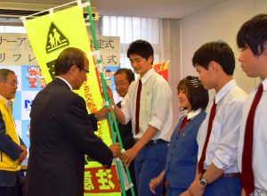 県交通安全協会からのぼりなどを受け取る自転車マナーアップ隊の生徒
