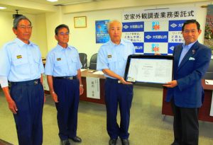 地図やデジタルカメラを上田清市長(右)から受け取る消防団員