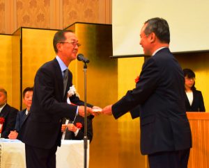 寄付金を贈呈する県遊技業協同組合の相羽宗一郎理事長（左）