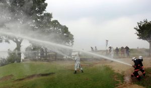 若草山山頂から出火場所と想定した谷間の山林に向けて放水する消防隊員ら
