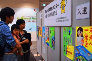 投票を呼びかけるポスターを見る買い物客