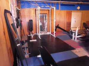 環境清美センターの駐車場棟４階に私設されているトレーニング室。ベンチプレスの用具やダンベルが多数置かれている（奈良市提供）