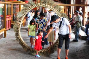 茅の輪をくぐって夏の健康を祈る参拝者