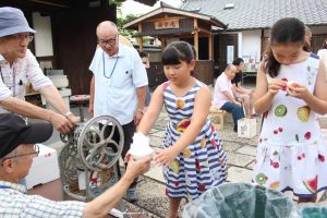 境内では昔ながらの手動かき氷機を使って子供らにかき氷がふるまわれた