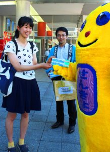 選挙管理委員やめいすいくんが通行人に割りばしを渡し投票を呼びかけた