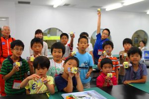 完成させた金星探査機「あかつき」を掲げる子供たち