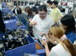 西垣社長の説明を聞きながら工場を見学する学生