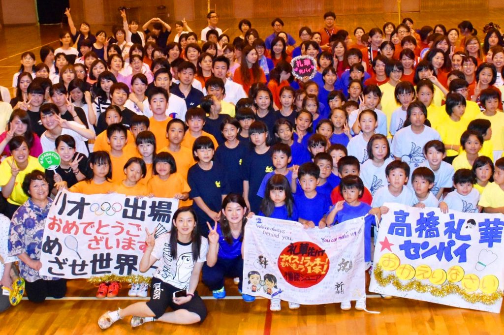 贈られた寄せ書きを手にＶサインする高橋礼華さん（前列中央）