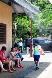 ミスト下のベンチで休憩する観光客ら