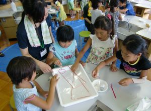 せっけん膜を使った実験に取り組む児童