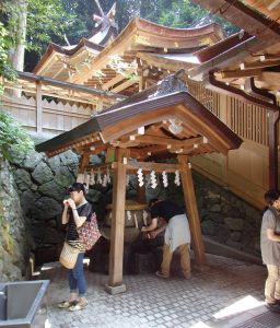 狭井神社の拝殿横にある薬井戸。厳しい暑さの中、参拝者らがのどを潤す