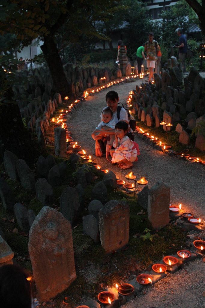 石仏、石塔の前に灯明が供えられ、境内が幻想的な雰囲気に包まれた