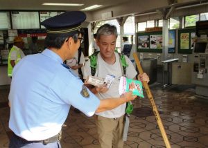 吉野署員から啓発グッズを受け取る登山者(県警提供)
