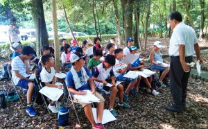 森の中で授業を受ける子供たち