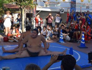 相撲のデモンストレーションを見学する外国人観光客ら