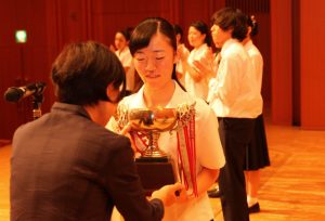 声楽部門でグランプリを獲得し、トロフィーを受け取る吉中萌華さん