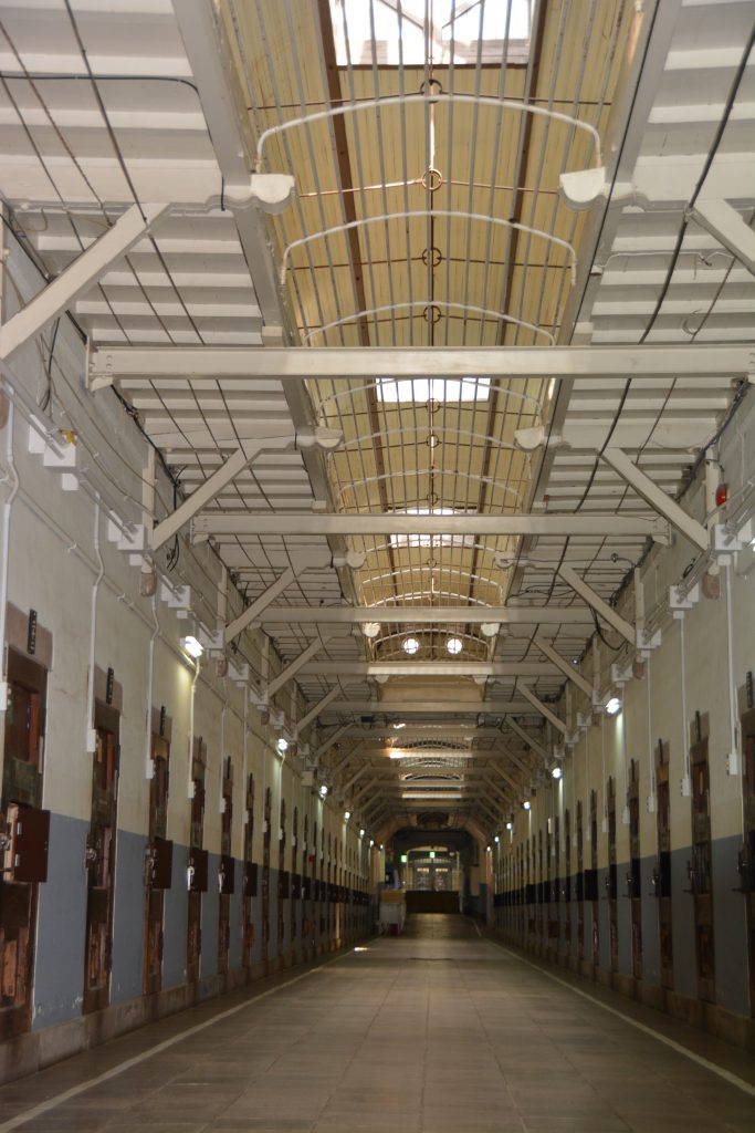 収容棟の廊下には天窓が。居室の木製ドアも当時のままだ