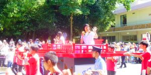 金メダルを見せながら輿に乗ってパレードする高橋、松友の両選手。市民から祝福を受けた