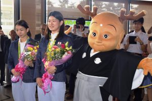 県庁玄関で、大勢の職員や県民に出迎えられるタカマツペア