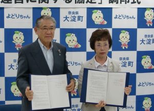 福祉避難所の設置・運営の協定書に調印した岡下町長(左)と東理事長