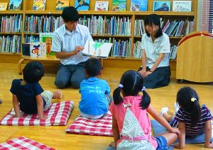 子供たちに読み聞かせをする生徒