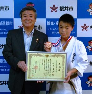 松井市長(左)に空手道選手権3位入賞を報告する村井君