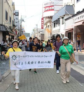 横断幕を掲げて三条通りを歩く参加者