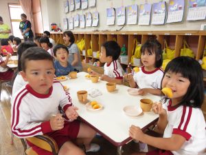 おいしい柿をほおばる園児