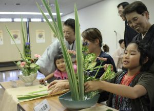 「親子いけばな体験教室」で講師のアドバイスを受け、思い思いに生け花を楽しむ参加者