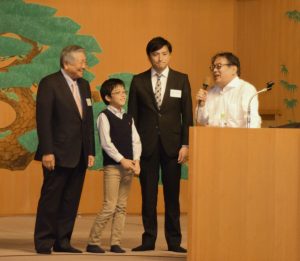 奈良豊澤酒造の(左から)豊澤安男会長、孝彦社長、社長の長男、光希君と、酒を勧める歌を唱和する奈良大の上野誠教授(右端)