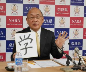 今年を表す漢字に「学」を選んで発表する荒井正吾知事