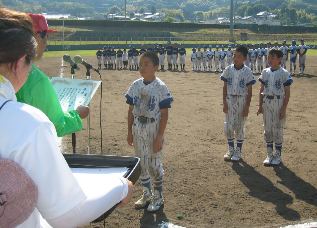 大和郡山ロータリークラブの谷野光司郎会長から優勝の表彰状を受け取る斑鳩少年野球部の選手