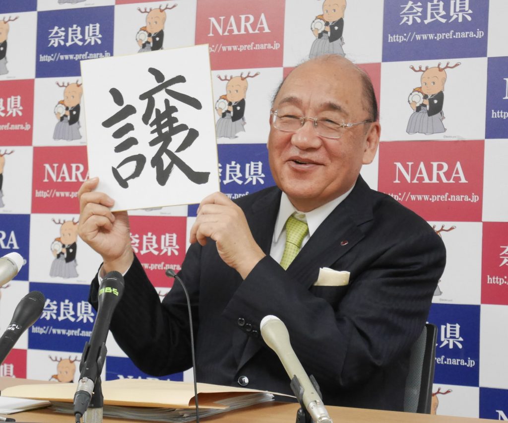 自筆の「譲」の漢字を掲げる荒井正吾知事